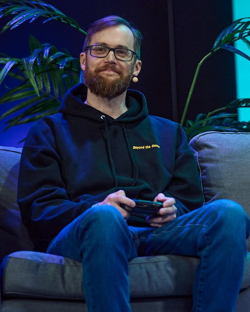 Tobias M. Scholz on stage with a game controller
